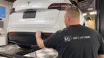 Tesla Model Y being ceramic coated by Liberty Autoworx employee